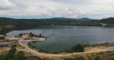 Mining quarry with flooded bottom. Lake with blue water near sand pit. Sipalay, Negros, Philippines.