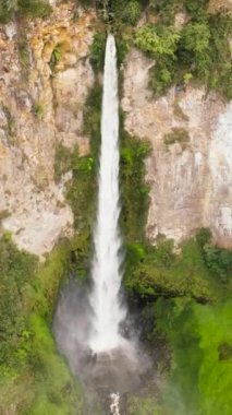 Tropikal dağ ormanındaki şelalenin havadan görünüşü. Sipiso Piso düşüyor. Sumatra, Endonezya.