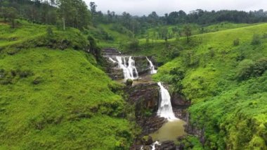 Şelalenin havadan görünüşü, çay tarlaları ve tropikal bitki örtüsü olan tepeler. St. Clair Şelalesi, Sri Lanka.