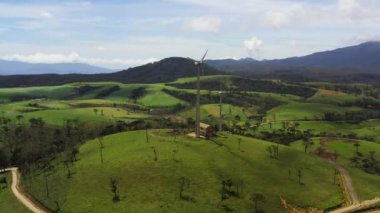 Wind turbines among green pastures and hills. Wind power plant. Ambewela, Sri Lanka.