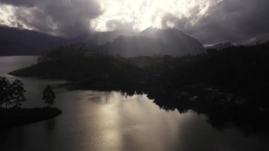 Dağlarda göl tepelerin arasında ve gün batımında çay tarlaları. Maskeliya, Maussakelle rezervi, Sri Lanka.