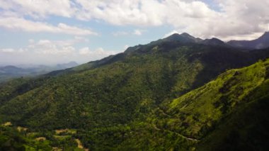 Taze yeşil yapraklar, tropikal bitkiler ve ağaçlar dağları ve vadiyi kaplar. Sri Lanka 'daki dağ manzarası.