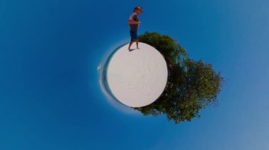 Tropik bir plajda koşan bir adam kumsalda koşar. Ultra geniş açı görünümü.