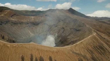 Aktif volkanı olan krater, Doğu Jawa, Endonezya 'da duman. Gunung Bromo Dağı, Tengger Semeru Ulusal Parkı 'nda aktif bir volkandır. 4K video. Hava görüntüleri.