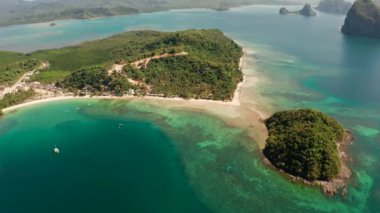 Deniz Burnu 'nun kumlu ve mavi suyu olan insansız hava aracı. Deniz manzarası, kum, palmiye ağaçları. Las Cabanas, El Nido, Palawan, Filipinler. Yaz ve seyahat tatil konsepti