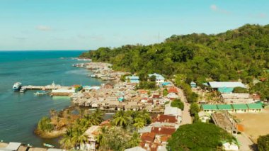 Balıkçı köyünde suyun içinde duran ev halkı. Filipinler, Palawan 'daki Balabac Adası' ndaki şehir limanı. Balıkçı köyünde denizin üzerinde duran eski ahşap bir ev.