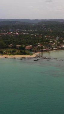 Şehir plajı ve balıkçı tekneleriyle Trincomalee kasabasının hava manzarası. Sri Lanka. Dikey video.