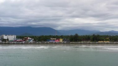 Okyanus dalgaları ve sörfçülerle dolu büyük kumlu bir sahil. Otellerin ve turistlerin dinlendiği sahil şeridi. Sabang Sahili, Baler, Aurora, Filipinler. Yaz ve seyahat tatil konsepti.