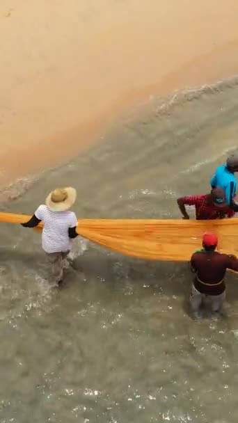 海岸の漁師は魚を集めるために海から網を引く トリノコマリー バーティカルビデオ — ストック動画