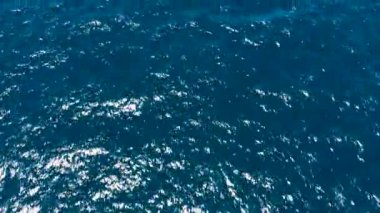 Mavi deniz suyunun havadan görünüşü. Mavi deniz suyunda güneşin parlaklığı.