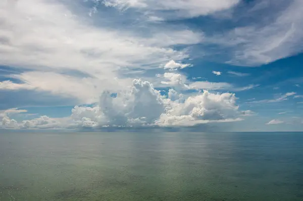 Blue sea and sky with clouds, view from the drone. Flight over the sea.