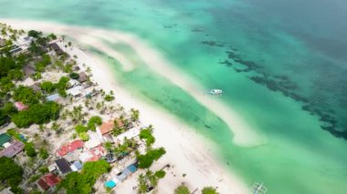 Palmiye ağaçları ve dalgalı denizleri olan güzel kumlu bir sahil. Bantay Adası, Filipinler.