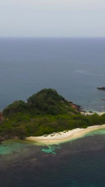 Kumlu bir plajı ve mercan resifleriyle çevrili gök mavisi suyu olan bir ada. Güvercin Adası, Sri Lanka. Dikey video.