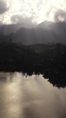 Dağlarda göl tepelerin arasında ve gün batımında çay tarlaları. Maskeliya, Maussakelle rezervi, Sri Lanka.