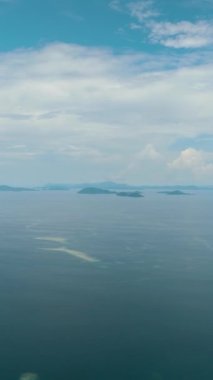 Mavi okyanus ve bulutlu mavi gökyüzü. Tropik bölgelerde deniz manzarası. Denizin üzerinden uçmak. Borneo, Malezya.