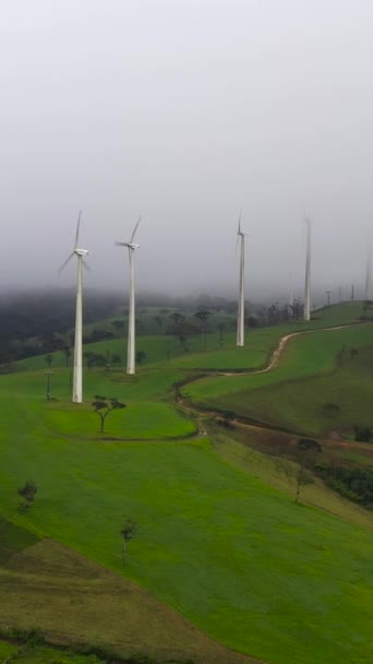 Sis Bulutların Arasındaki Dağlardaki Rüzgar Türbinlerinin Üst Görüntüsü Yenilenebilir Elektrik — Stok video