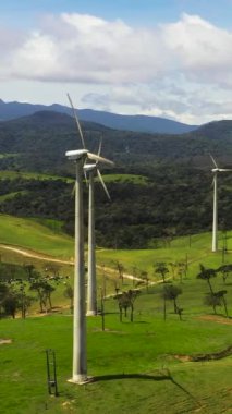 Wind turbines among green pastures and hills. Wind power plant. Ambewela, Sri Lanka.