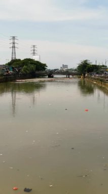 Kirlenmiş Ciliwung nehri, Endonezya 'nın Jakarta kenar mahallelerinde çöplerle doludur..