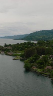 Toba Gölü ve Samosir Adası 'nın insansız hava aracı. Tuk Tuk geleneksel köy ve turizm merkezi. Sumatra, Endonezya. Tropikal manzara.