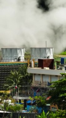 Dumanı tüten ve buharı olan jeotermal enerji santrali. Bir enerji santralinde yenilenebilir enerji üretimi. Zenciler, Filipinler.
