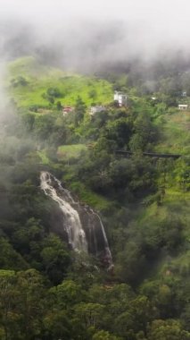 Sis ve bulutlarla kaplı dağlarda şelale. Kital Ella Şelalesi, Sri Lanka.