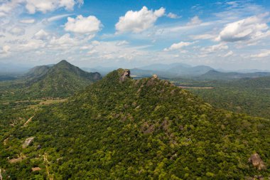 Yeşil ormanlarla kaplı dağların ve ormanın mavi gökyüzüne ve bulutlara dayandığı vadilerin hava aracı. Sri Lanka.