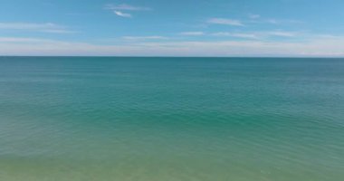 Gökyüzüne ve bulutlara karşı dalgalı açık mavi deniz manzarası. Tropik bölgelerde deniz manzarası. Borneo, Malezya.