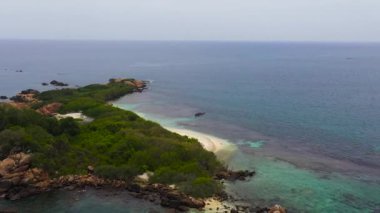 Tropikal kumlu ve mavi okyanuslu deniz burnu. Güvercin Adası, Sri Lanka.