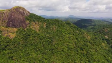 Mountains covered rainforest, trees and blue sky with clouds. Sri Lanka.