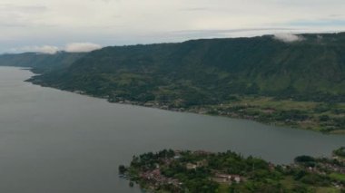 Toba Gölü 'ndeki Tuk Tuk Tuk ve Samosir Adası sahilleri. Sumatra, Endonezya. Tropikal manzara.