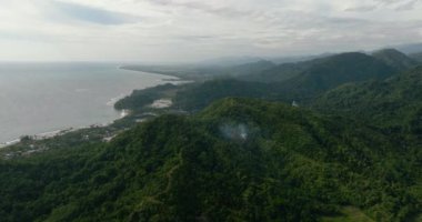 Sumatra adasının kıyısında kasabalar ve ormanlı dağlar var. Endonezya.