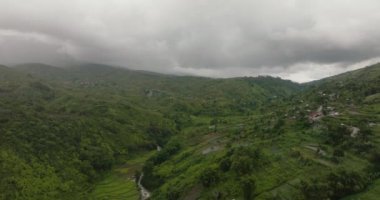 Dağların yamaçlarındaki çiftliklerin arasındaki köyün havadan görünüşü. Sumatra. Endonezya.