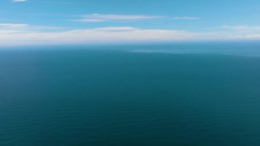 Gökyüzüne ve bulutlara karşı dalgaları olan açık mavi denizin insansız hava aracı. Tropik bölgelerde deniz manzarası. Borneo, Malezya.