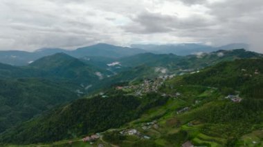 Dağların yamaçlarındaki tarım arazilerinin insansız hava aracı. Tropiklerde yeşil bitki örtüsü olan dağlar ve tepeler. Borneo, Sabah, Malezya.
