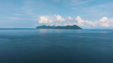 Mavi denizdeki tropikal adaların bulunduğu deniz burnu gökyüzünün arka planında ve bulutlarda. Tun Sakaran Deniz Parkı, Sabah, Malezya.