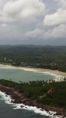 Plajı ve palmiye ağaçları arasında otelleri olan sahil. Dickwella Plajı, Sri Lanka.