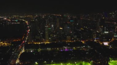 Manila şehrinin aydınlık gökdelenleri ve geceleri liman manzarası.