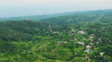 Dağlık bir vilayetteki tarım arazileri arasındaki çiftçi evlerinin havadan görünüşü. Cebu Adası, Filipinler.