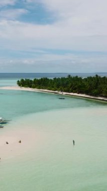 Mavi denizde mercan kayalıkları ve kumsalı olan bir ada. Onok Adası, Balabac, Filipinler.