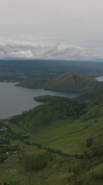 Toba Gölü 'ndeki Samosir Adası dağlarla çevrili. Sumatra, Endonezya. Dikey video.