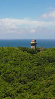 Okyanusun ve mavi gökyüzünün arka planına karşı bir pelerin üzerindeki deniz feneri. Engano Burnu. Palaui Adası. Santa Ana Filipinleri.