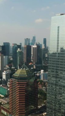 Jakarta şehrinin ilçeleri ve gökdelenler yukarıdan görünüyor. Dikey video.
