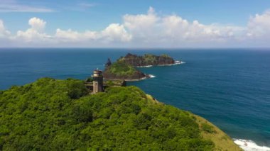 Pelerin üzerindeki eski bir deniz feneri okyanusun ve mavi gökyüzünün arka planına karşı. Engano Burnu. Palaui Adası. Santa Ana Filipinleri.