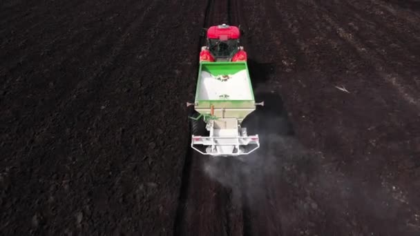 農地のトラクターは 収量を向上させるために乾燥肥料を適用します — ストック動画