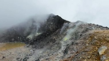 Sibayak Dağı 'nın yamacında sülfür kalıntılarıyla kaplı dumanlı fümerol. Sumatra, Endonezya.