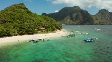 Kumlu plajlı, yeşil yapraklı ve palmiye ağaçlı hava aracı tropikal adası. Gök mavisi ve berrak suyu olan bir göl. El Nido, Palawan Filipinleri 'ndeki helikopter adası. Yaz ve seyahat tatil konsepti
