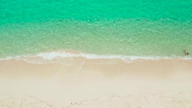 Dalgalı ve turkuaz suyu olan tropik kumlu sahil, metin için kopyalama alanı, hava manzarası. Gölde deniz suyu yüzeyi. Şeffaf turkuaz okyanus suyu yüzeyi. Arkaplan dokusu
