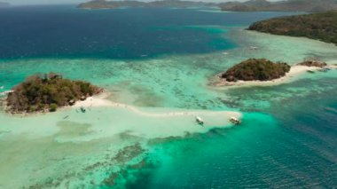 Beyaz kumlu ve berrak mavi denizli tropik plaj manzarası. Adaları ve plajları olan tropik bir manzara. Filipinler, Palawan.
