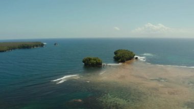 Okyanustaki tropik adalar, kıyıya vuran dalgalar, üst manzara. Siargao, Filipinler. Yaz ve seyahat tatil konsepti.