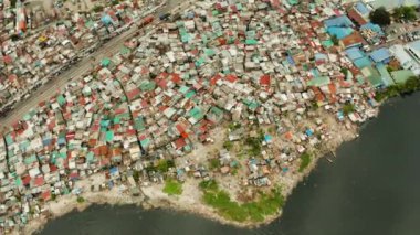 Manila 'da gecekondu mahallesi, Phillippines, manzaralı. Suda bir sürü çöp var..